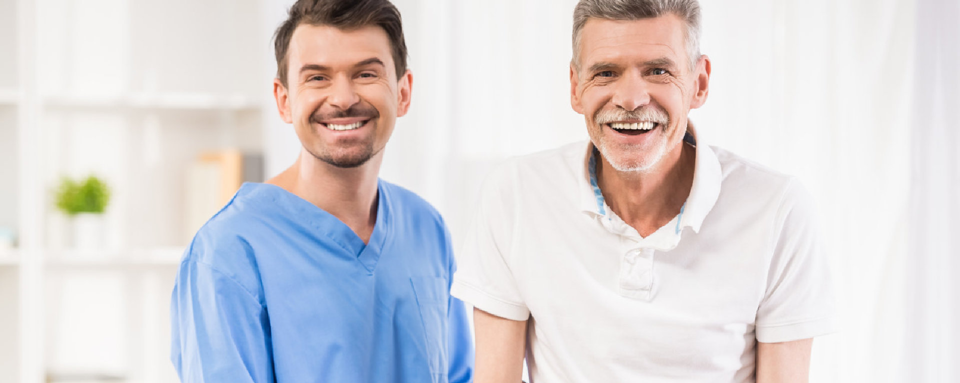 senior man and male caregiver smiling