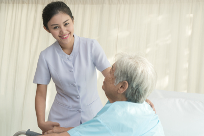 cheerful caregiver visiting senior patient